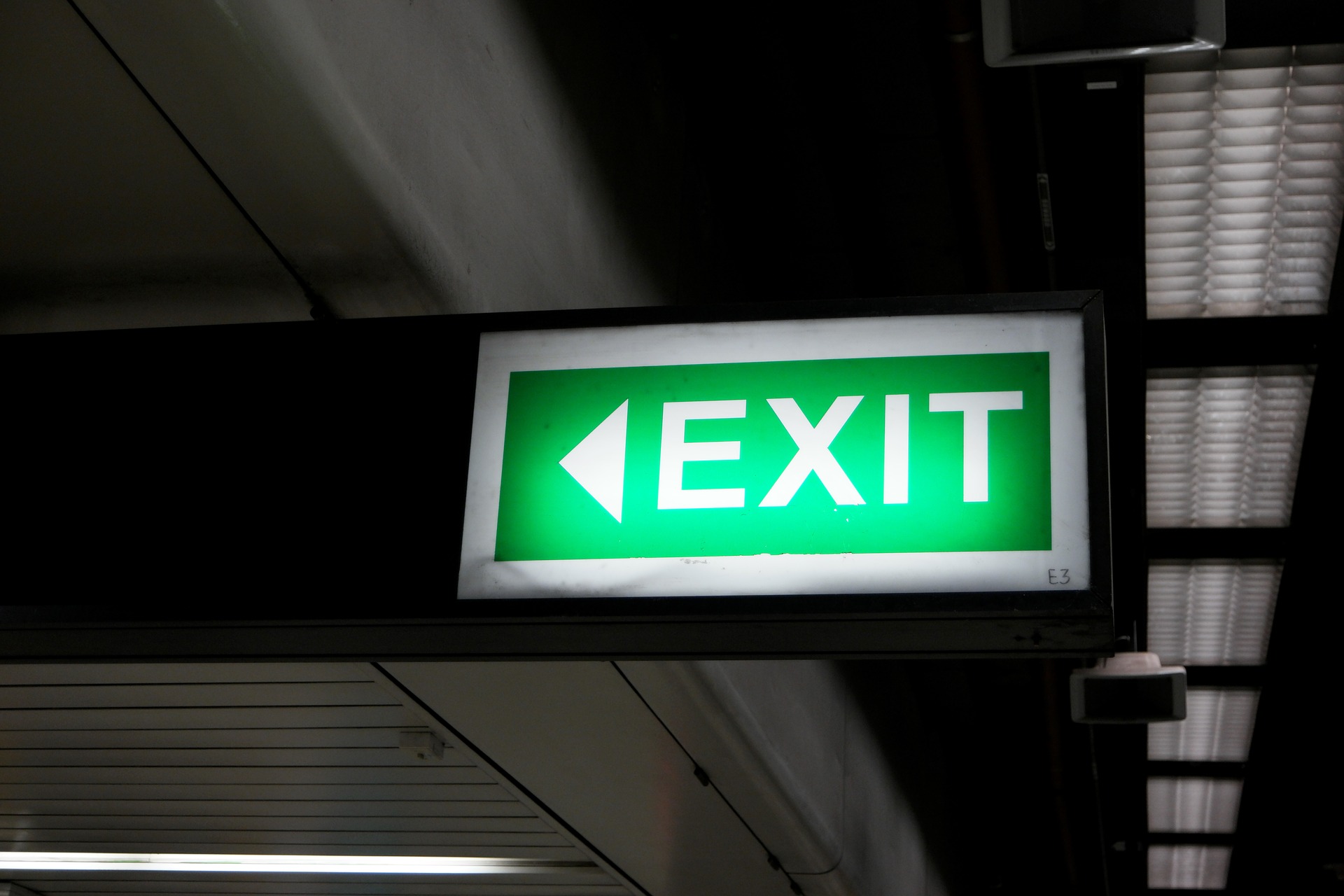 Green emergency exit sign indicating safe evacuation route
